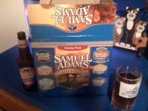 Samuel Adams Harvest 12-pack with an open bottle of Harvest Pumpkin Ale