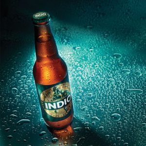 Bottle of Indio on wet surface with beads of water