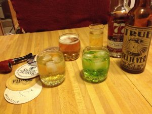Glasses filled with colorful cocktails made with cider, whiskey and other ingredients