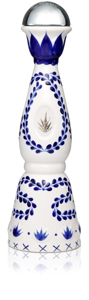 A white ceramic bottle of Clase Azul Reposado with blue-leaf motif and and embossed silver agave leaf