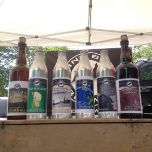 Aluminum bottles of Yorker Ale, Commack Common Ale, Echolocation IPA, Midnight Train to Jodhpur, and glass bottles of Purgatory Porter and Hells Gate Golden Ale