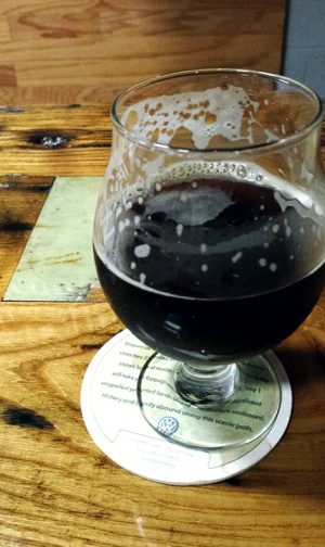 A tulip glass with a dark beer from Destination Unknown