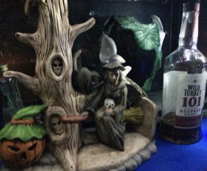 A ceramic Halloween decoration next to a bottle of Wild Turkey 101 Bourbon