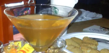 A martini glass with filled with a Corkscrew cocktail