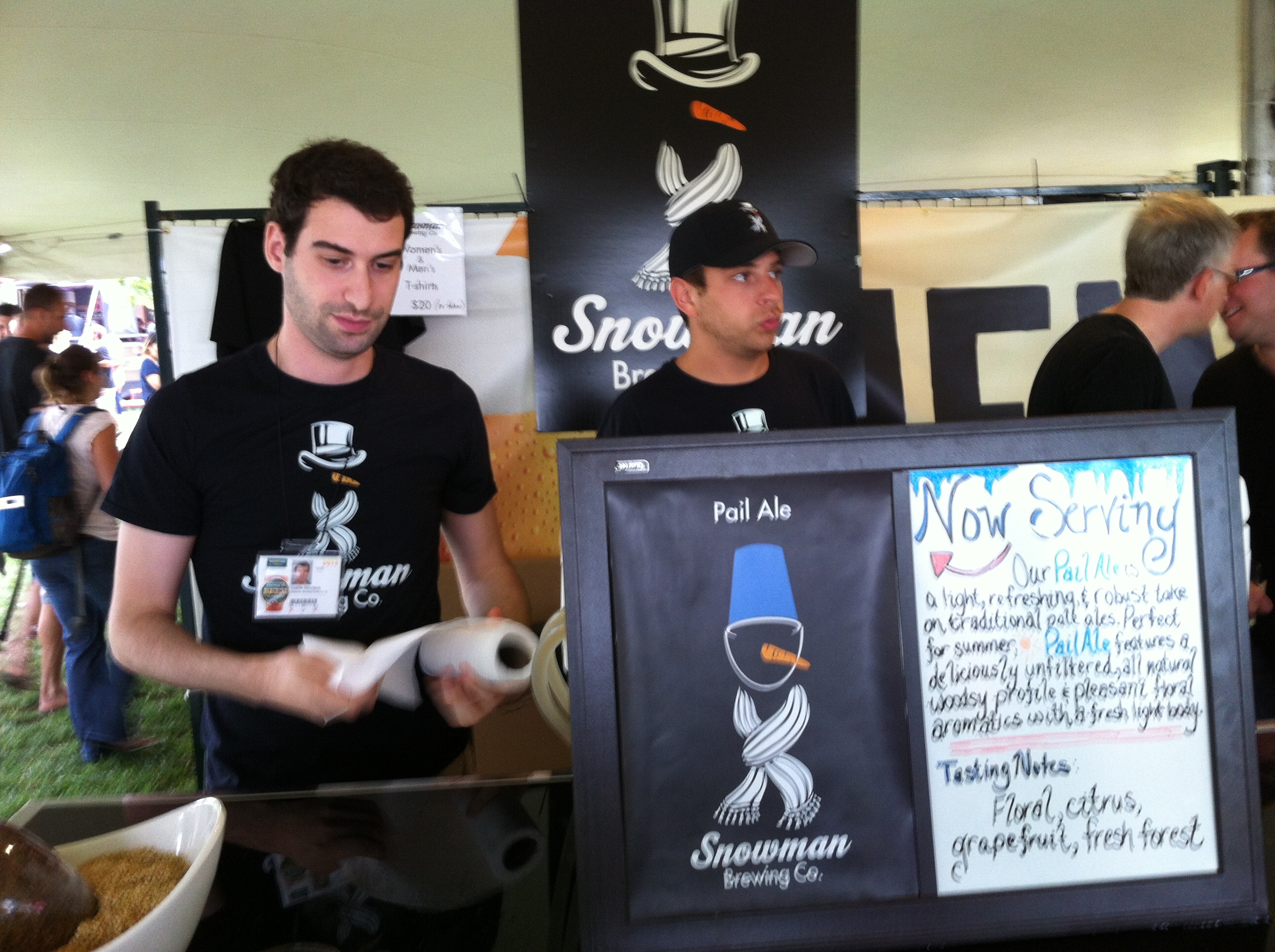 Two gentlemen in black Snowman Brewing Co. t-shirts wait to pour Pail Ale at Toronto’s Festival of Beer
