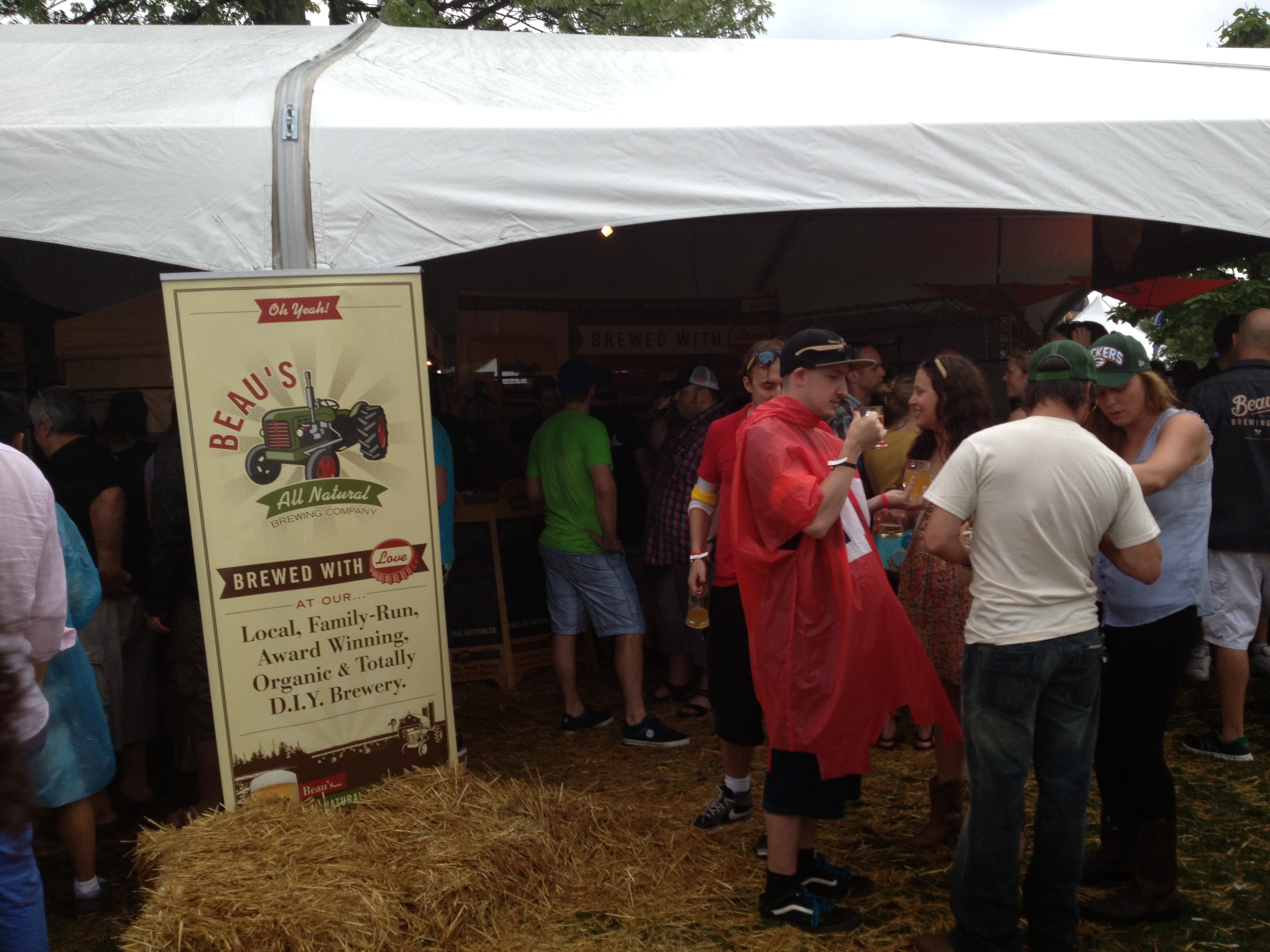 People hover under Beau’s All Natural tent on a rainy day at Toronto’s Festival of Beer 2013.