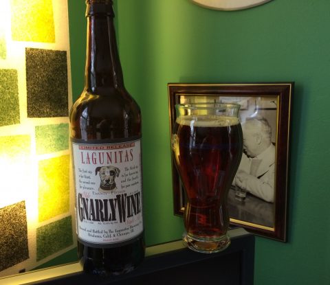 A bottle of Lagunitas GnarleyWine with a glass filled with the dark caramel-colored beer.