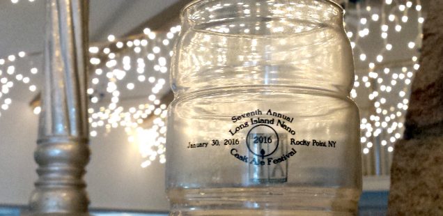 A cask shaped glass from the 2016 Long Island Nano Cask Ale Festival with a small amount of dark beer lingering in the glass